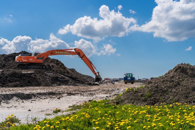 Grond wordt bouwrijp gemaakt bij 't Veld Noord met de inzet van een kraan.